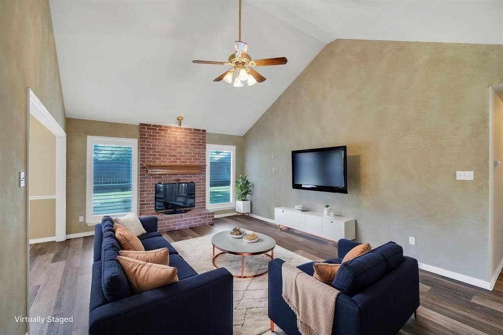 506 Whitney Drive, Midlothian, TX 76065 Spacious living area featuring a vaulted ceiling with a ceiling fan, brick fireplace, wood-finish flooring, and multiple large windows