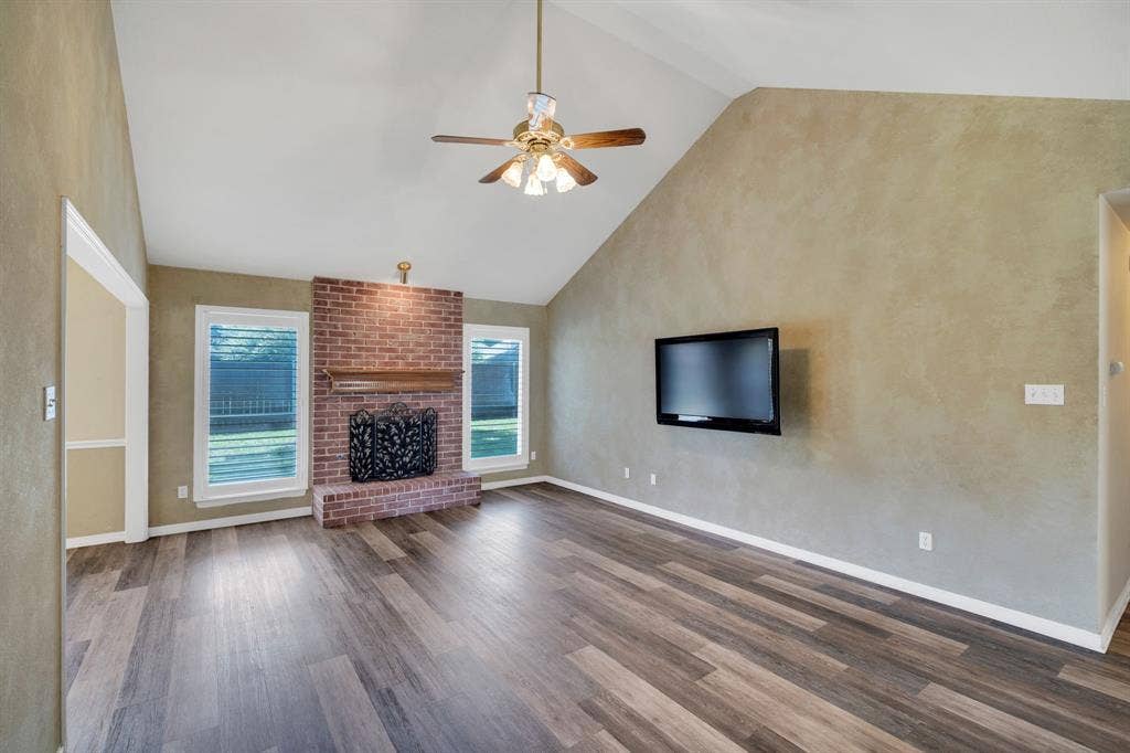 506 Whitney Drive, Midlothian, TX 76065 Spacious living area featuring a brick fireplace with a wood mantel, vaulted ceiling, and wood-finish flooring