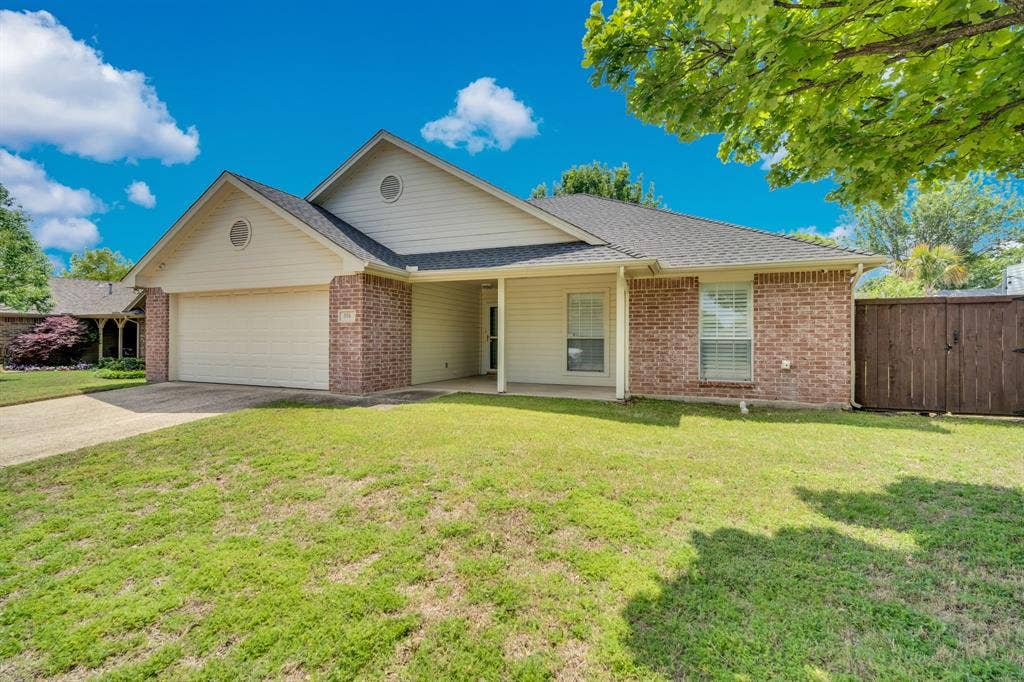 506 Whitney Drive, Midlothian, TX 76065 Single-story residence featuring a brick and siding exterior, an attached garage, a covered front porch, and a wooden privacy fence