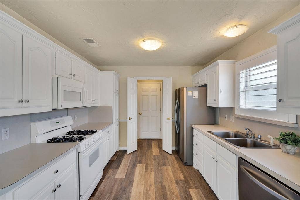 506 Whitney Drive, Midlothian, TX 76065 Kitchen featuring white cabinetry, wood-finish flooring, white appliances, and a stainless steel refrigerator