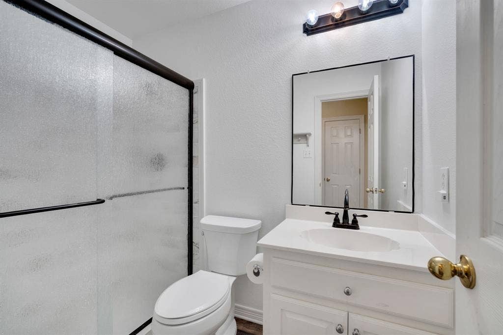 506 Whitney Drive, Midlothian, TX 76065 Bathroom featuring a white vanity with an integrated sink, black faucet, and frameless mirror
