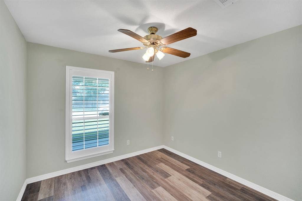 506 Whitney Drive, Midlothian, TX 76065 Bedroom featuring wood-finish flooring, a white trim window, and a ceiling fan with integrated lighting