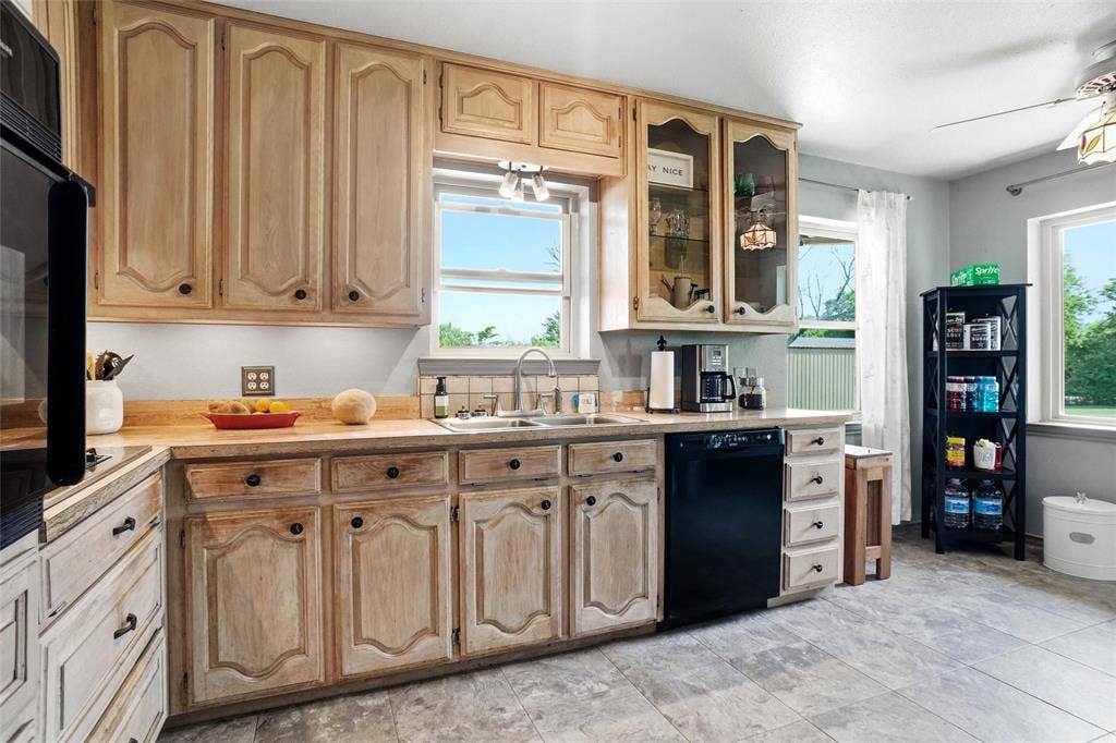 8983 W Odneal Road, Krum, TX 76249 Show through glass doors on a couple of upper kitchen cabinets. Electric stove.