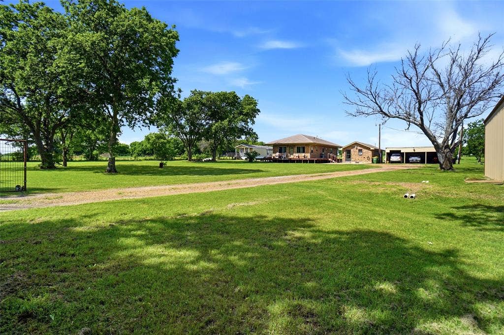 8983 W Odneal Road, Krum, TX 76249 Property has electric gate. There is a 3 carport structure and shop is on right hand side of the picture.