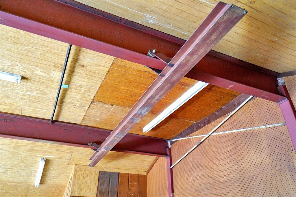 1114 Brookshire Drive, Tyler, TX 75071 Exposed red-painted steel I-beams support a plywood ceiling