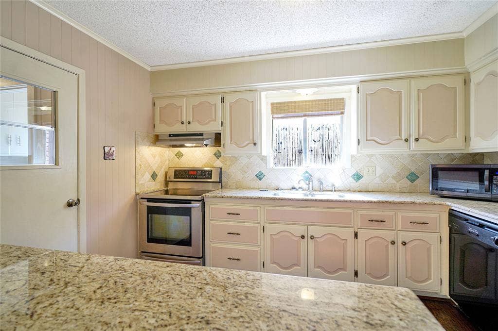1114 Brookshire Drive, Tyler, TX 75071 Kitchen featuring light-toned cabinetry, granite-finish countertops, stainless steel electric range, and a tiled backsplash
