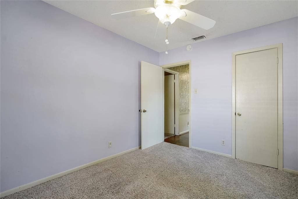 1114 Brookshire Drive, Tyler, TX 75071 Carpeted room with a ceiling fan light fixture and a solid white door