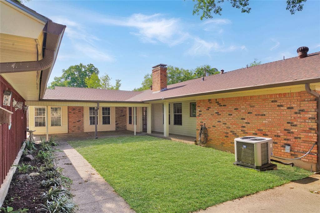 1114 Brookshire Drive, Tyler, TX 75071 Expansive outdoor courtyard with a manicured lawn, a covered walkway, and brick exterior accents