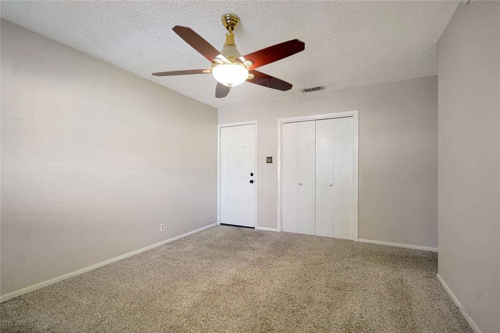 1114 Brookshire Drive, Tyler, TX 75071 Neutral-toned room featuring light beige carpeting, white walls, and a ceiling fan with integrated lighting