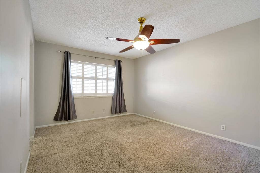 1114 Brookshire Drive, Tyler, TX 75071 Spacious room featuring neutral carpeting, light-toned wall paint, and a window with white louvered shutters