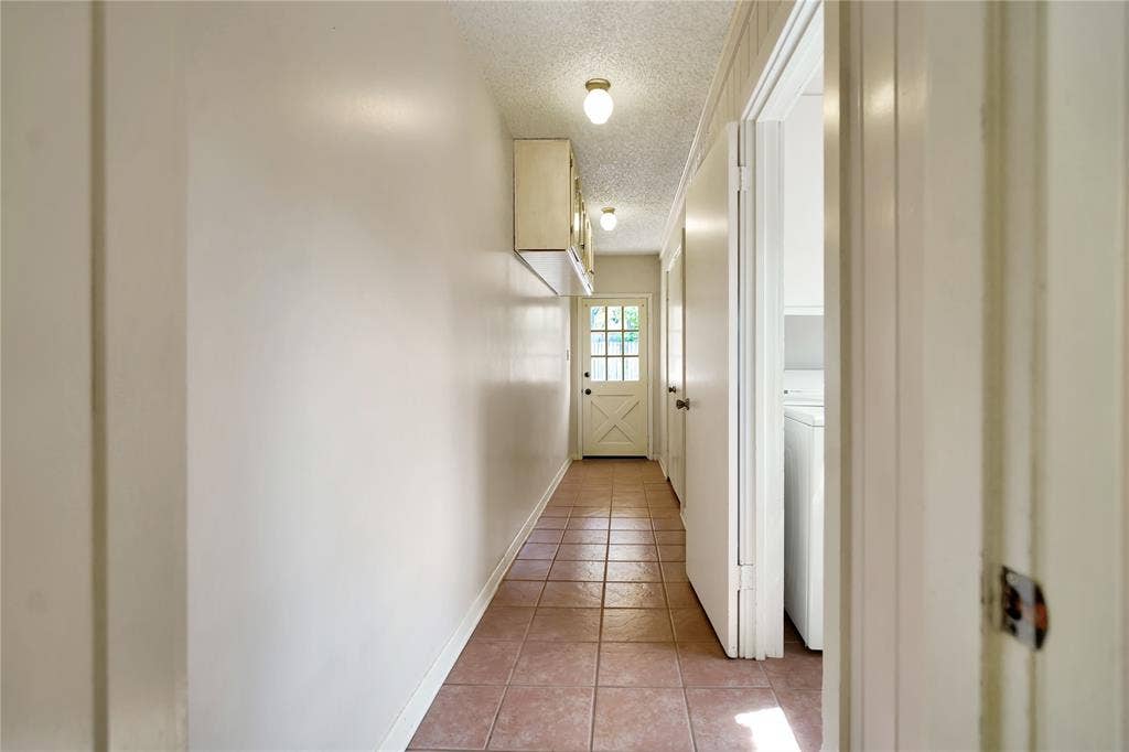 1114 Brookshire Drive, Tyler, TX 75071 Hallway featuring tile flooring, neutral wall paint, and a white paneled door with glass inserts