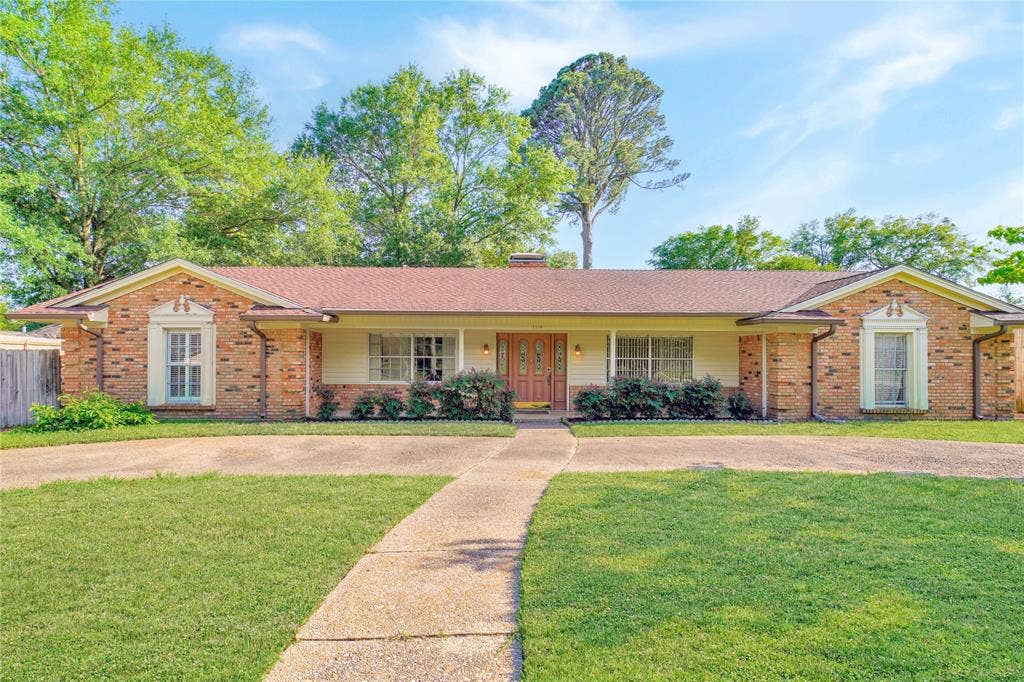 1114 Brookshire Drive, Tyler, TX 75071 Ranch-style residence featuring a brick and siding exterior, a prominent gable roof, and an inviting double entry door