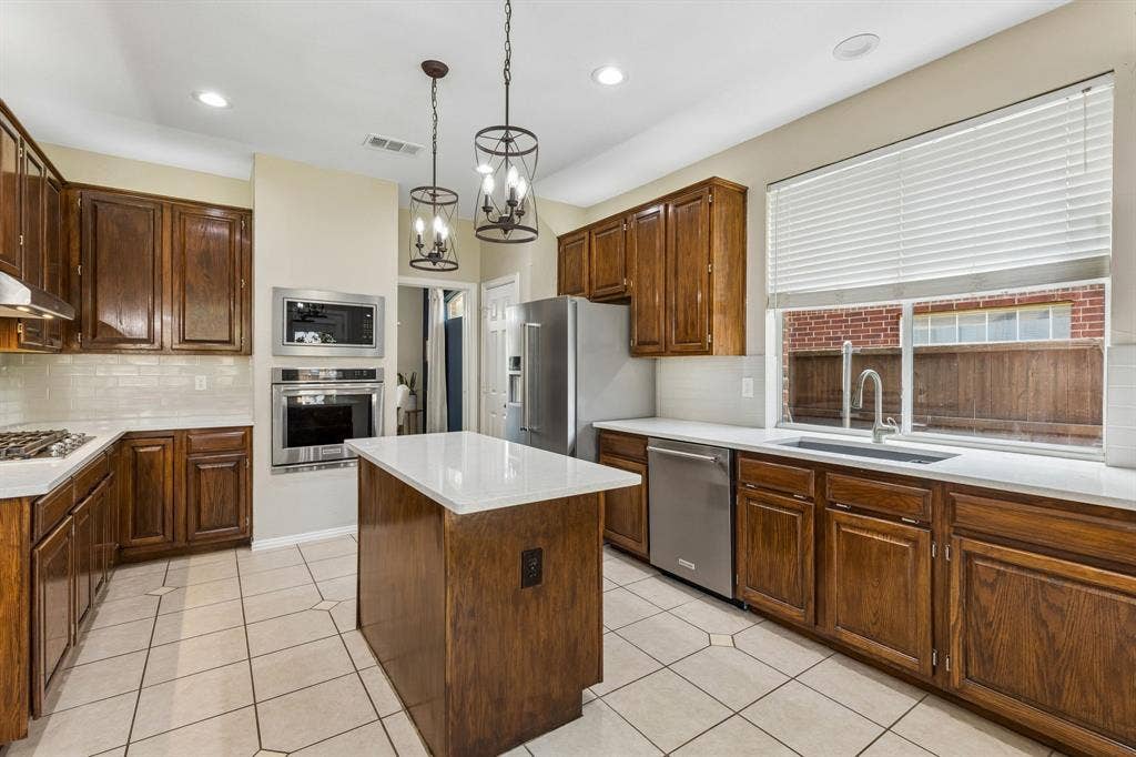 1105 Easton Lane, Allen, TX 75002 The kitchen boasts a blanco sink with window overlooking the work area. Under the sink find an 8 gallon hotwater heater for instant hot water. Other features of the space: 5 burner gas cooktop and stainless appliances including convection oven and a wall mounted microwave.