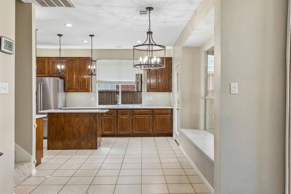 1105 Easton Lane, Allen, TX 75002 Thoughtfully laid out, the nook offers a window seat and stylish light fixture that coordinates with the pendant lights over the kitchen island. To the left of the stairway shown, is a door that leads to under the stair storage.