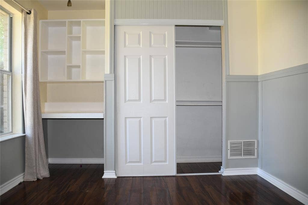 Dark wood-finish flooring with white baseboards throughout