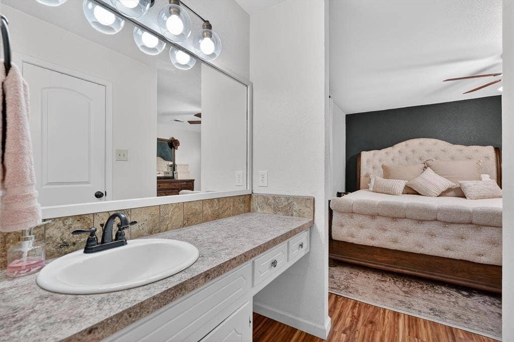 224 Hudson Avenue, Crowley, TX 76036 Bathroom vanity featuring an integrated sink with a two-handle faucet, a laminate countertop, and a tiled backsplash