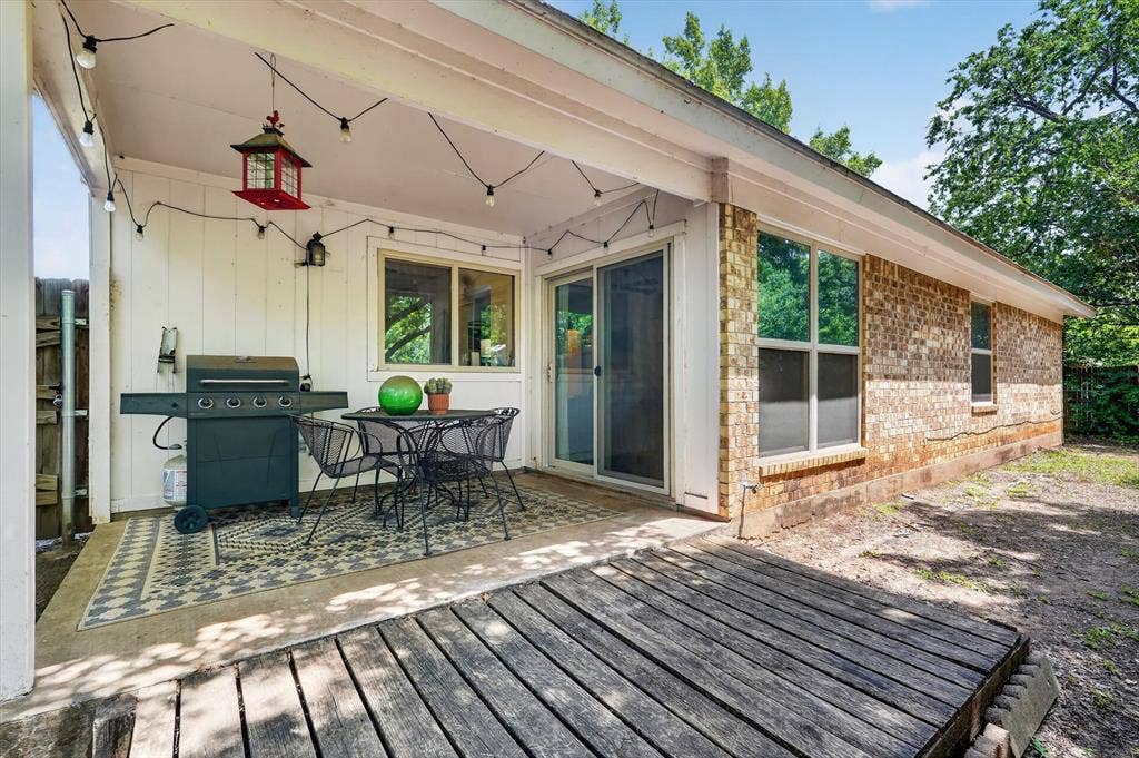 224 Hudson Avenue, Crowley, TX 76036 Covered patio space featuring a concrete slab, wood deck extension, and full brick exterior