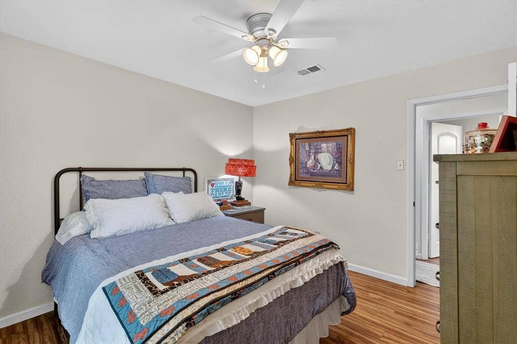224 Hudson Avenue, Crowley, TX 76036 Bedroom featuring wood-finish flooring, a ceiling fan with integrated lighting, and neutral wall tones