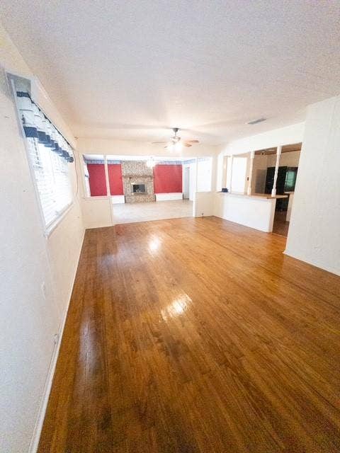 613 Laurel Road, Athens, TX 75751 Wood-finish flooring throughout, featuring a stone fireplace, open concept design, and a ceiling fan