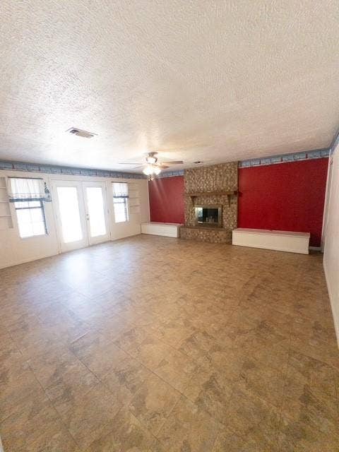 613 Laurel Road, Athens, TX 75751 Spacious room featuring neutral-toned tile flooring, a stone-clad fireplace with a mantel, and French doors
