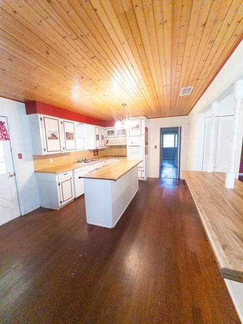 613 Laurel Road, Athens, TX 75751 Kitchen featuring a wood plank ceiling, white cabinetry with red trim, wood-finish countertops, a central island, and dark wood-finish flooring