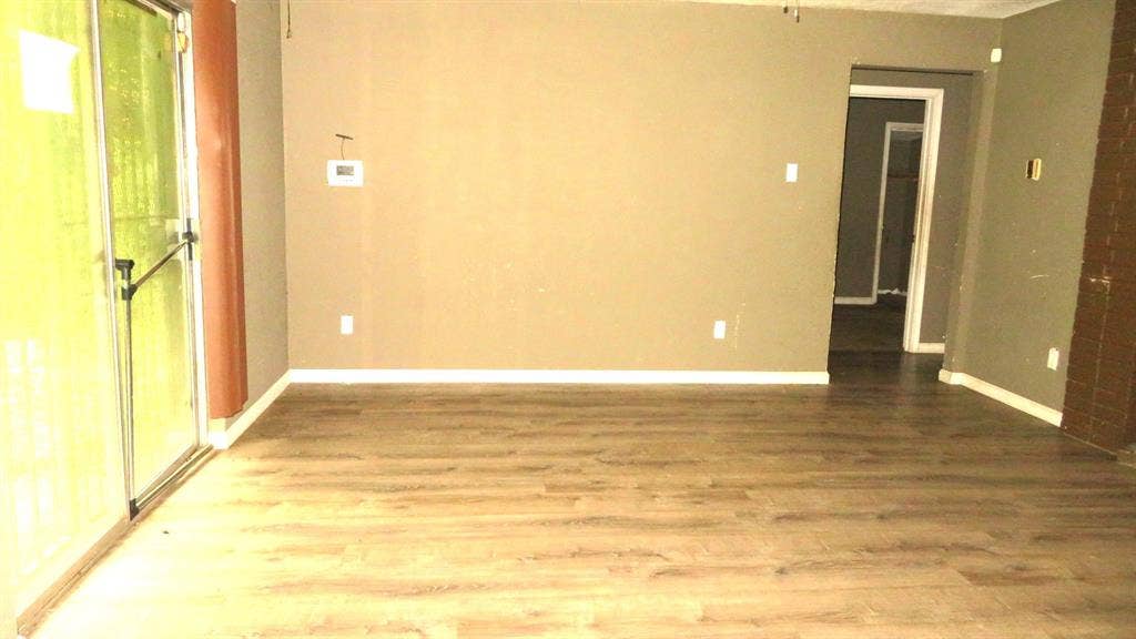 6525 Palm Island Street, Dallas, TX 75241 Expansive room featuring wood-finish flooring, a sliding glass door, and neutral wall tones