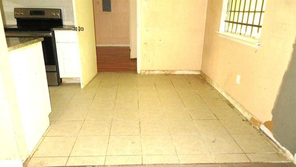 6525 Palm Island Street, Dallas, TX 75241 Tiled flooring throughout this space, featuring a window with security bars