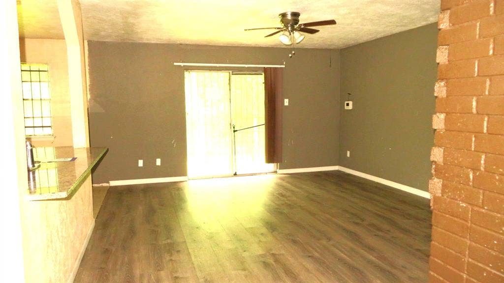 6525 Palm Island Street, Dallas, TX 75241 Spacious room featuring wood-finish flooring, a ceiling fan, and sliding glass doors