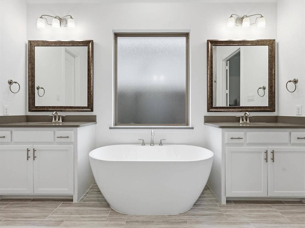 Enjoy a spa-like primary bath with separate vanities and a deep garden tub.