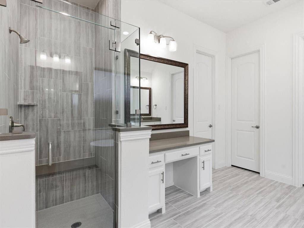 Primary bath offers ample counter space and storage, complemented by separate his and her walk-in closets.