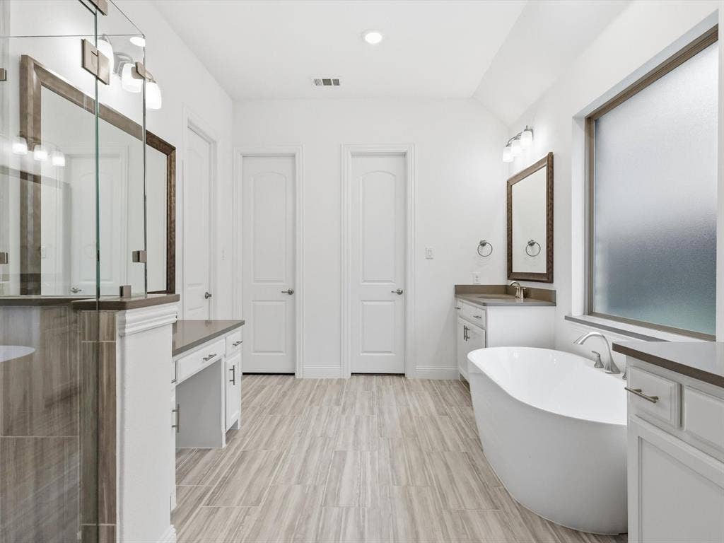 Primary bathroom featuring double vanities and generous storage.