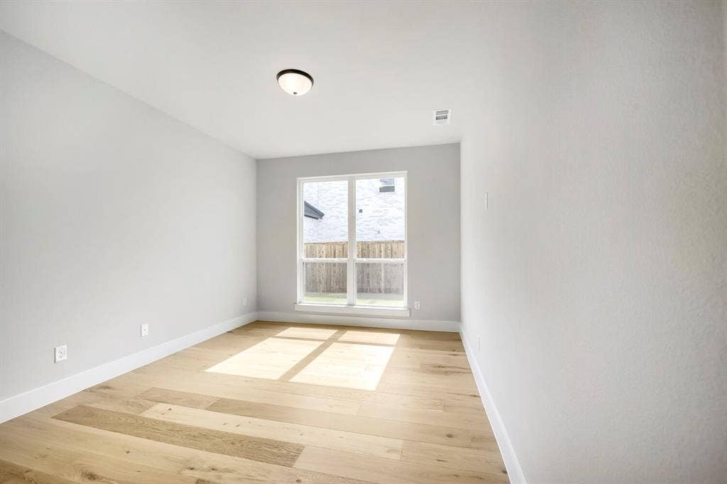 800 Blackberry Road, Haslet, TX 76052 Room featuring a large window, light wood-finish flooring, white baseboards, light neutral wall paint, and a flush-mount ceiling light fixture