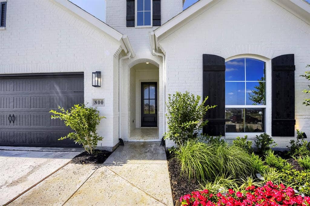 800 Blackberry Road, Haslet, TX 76052 White brick exterior with black shutters and a complementary dark garage door
