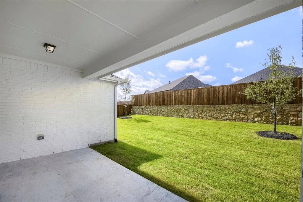 800 Blackberry Road, Haslet, TX 76052 Covered concrete patio with a white painted brick exterior wall