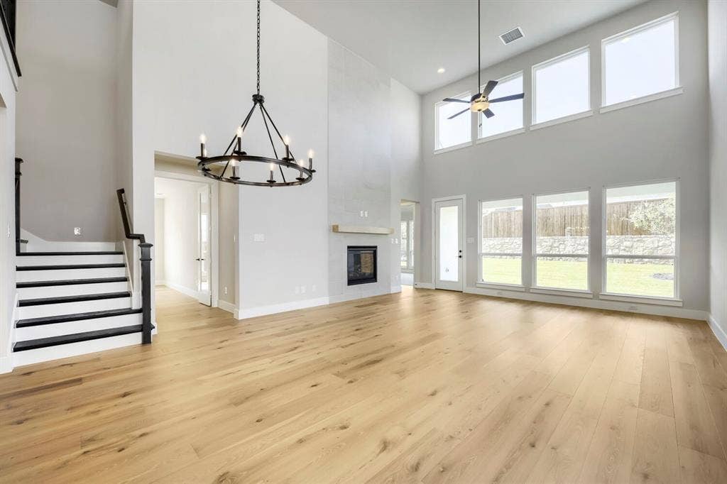 800 Blackberry Road, Haslet, TX 76052 Expansive living space featuring high ceilings, wood-finish flooring, and a contemporary fireplace
