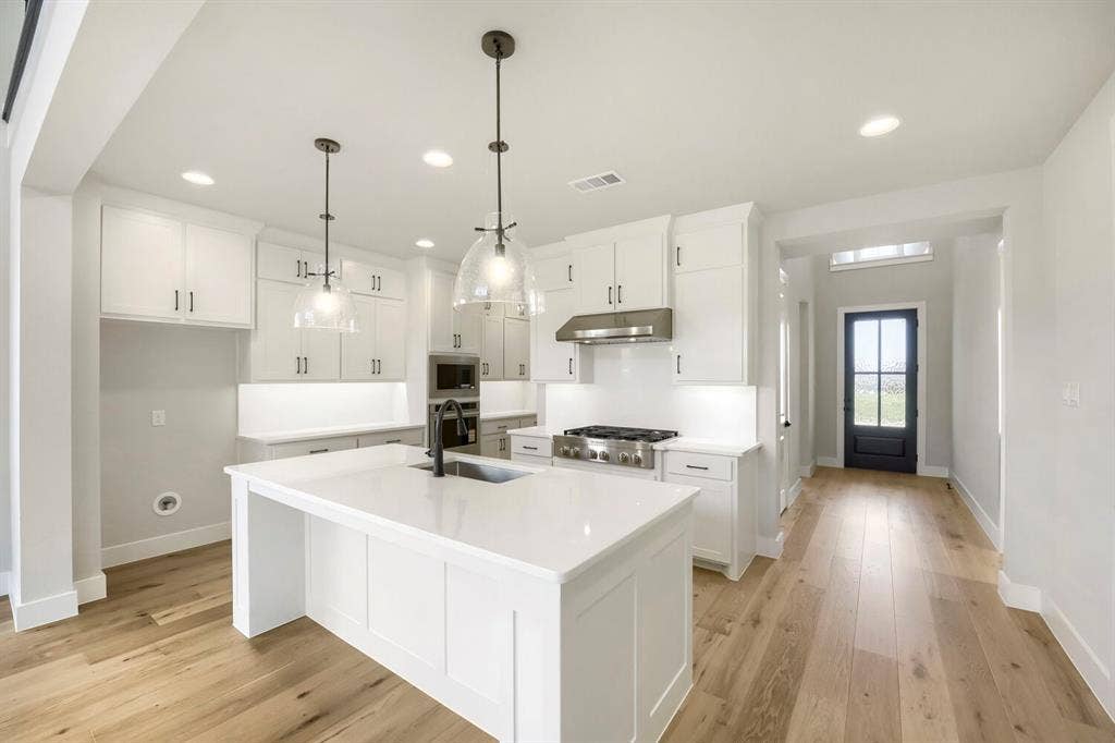 800 Blackberry Road, Haslet, TX 76052 Modern kitchen featuring white cabinetry, quartz countertops, a stainless steel gas range, and wood-finish flooring