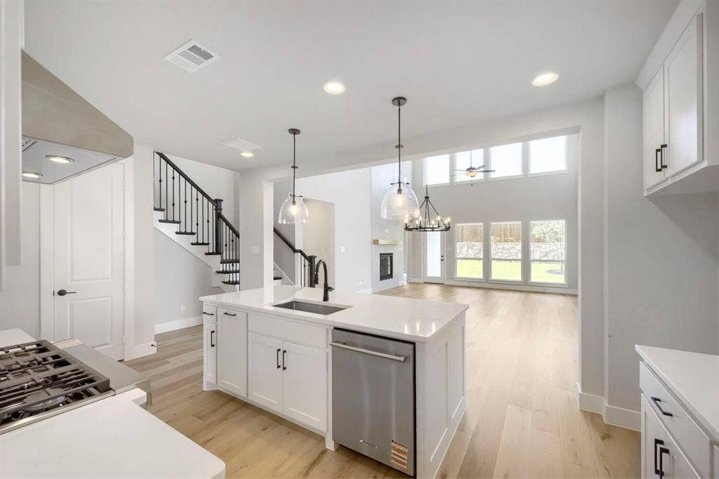 800 Blackberry Road, Haslet, TX 76052 Open-concept kitchen with a large island featuring a built-in sink, stainless steel dishwasher, and pendant lighting