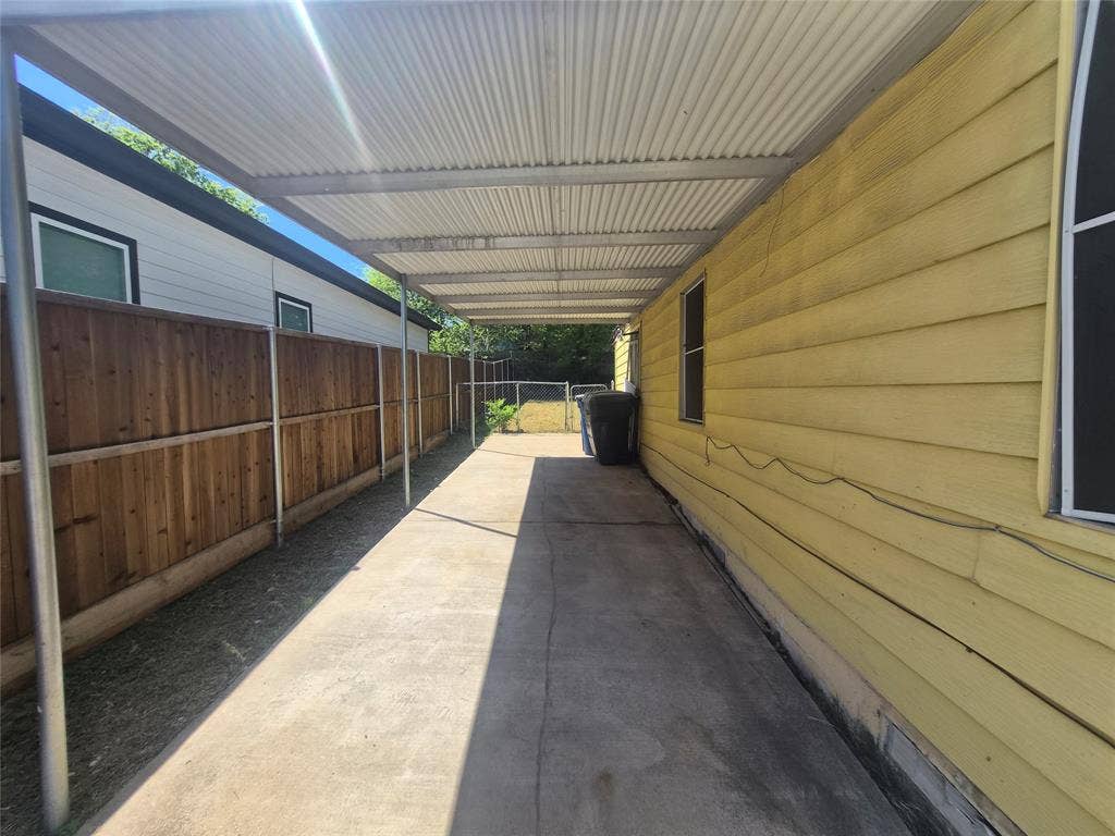 Covered concrete walkway extending alongside the property