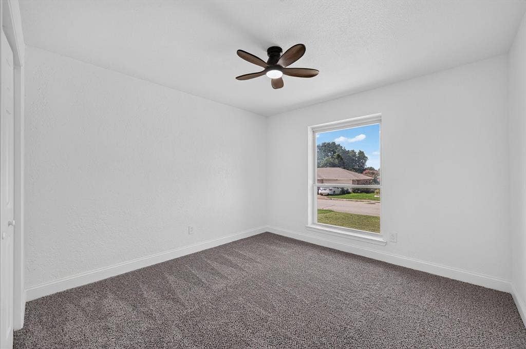 3420 Denbury Drive, Fort Worth, TX 76133 Spacious room featuring neutral carpeting, white wall finishes, and a single window offering exterior views