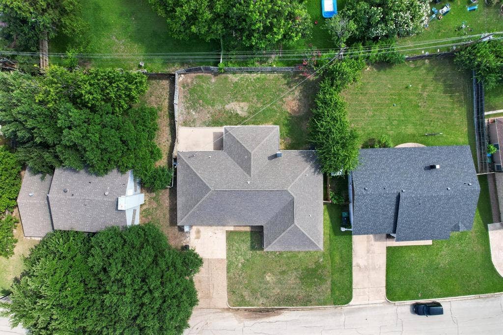 3420 Denbury Drive, Fort Worth, TX 76133 Gable roofline residence with a driveway, mature trees, and an expansive grassy yard