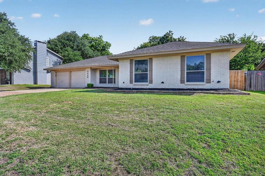 3420 Denbury Drive, Fort Worth, TX 76133 White brick exterior with a dark shingle roof and wood-look shutters
