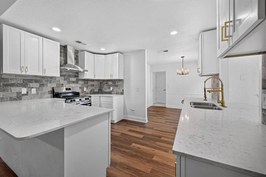 3420 Denbury Drive, Fort Worth, TX 76133 Modern kitchen featuring white cabinetry, light-colored countertops, a stainless steel range with a matching range hood, and a gray tile backsplash