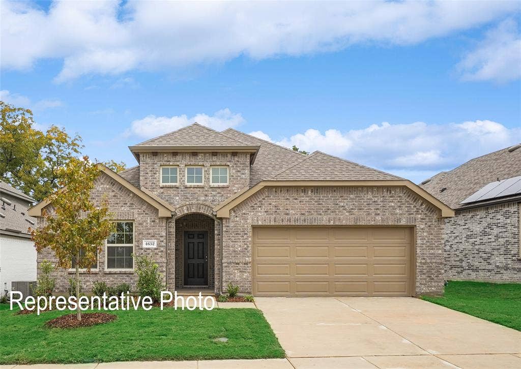 1579 Gentle Night Drive, Forney, TX 75126 Brick facade home with an arched entry, a two-car garage, and a gabled roofline