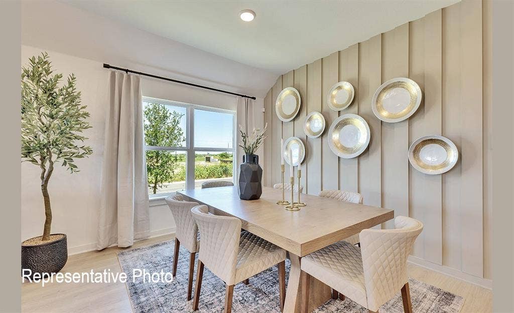 1579 Gentle Night Drive, Forney, TX 75126 Dining space featuring light wood-finish flooring, a contemporary accent wall with vertical paneling, and a large window with white trim