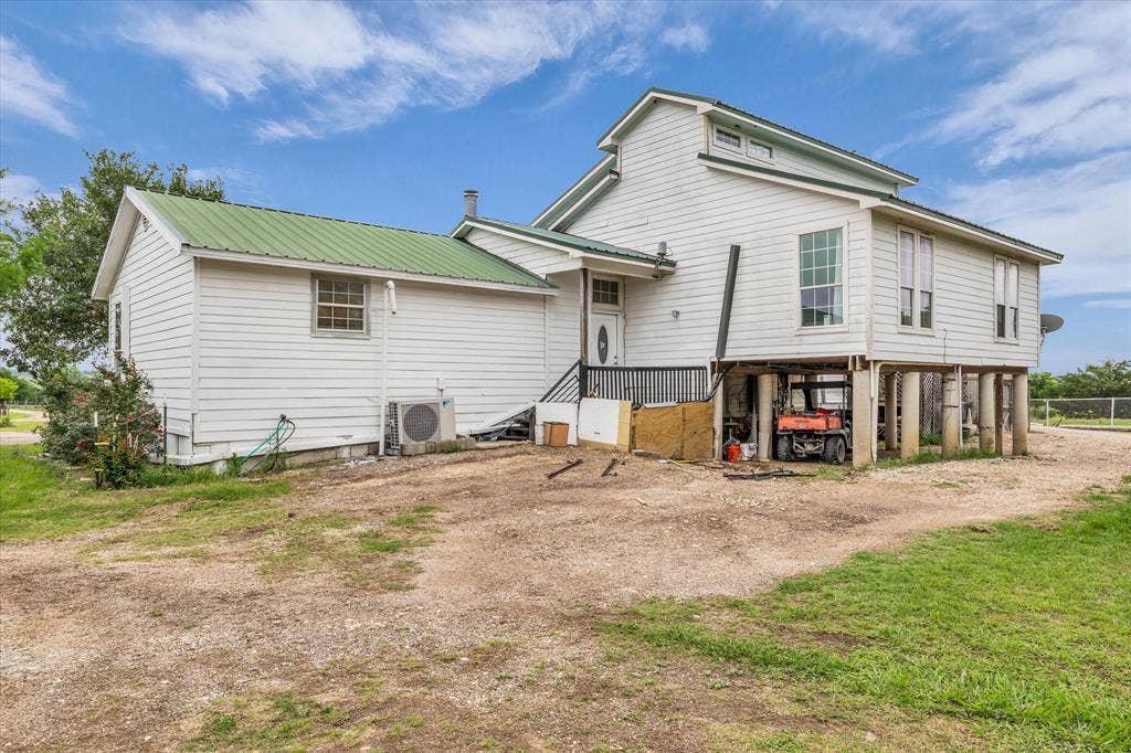 12912 Spring Valley Road, Moody, TX 76557 White siding exterior with a green metal roof
