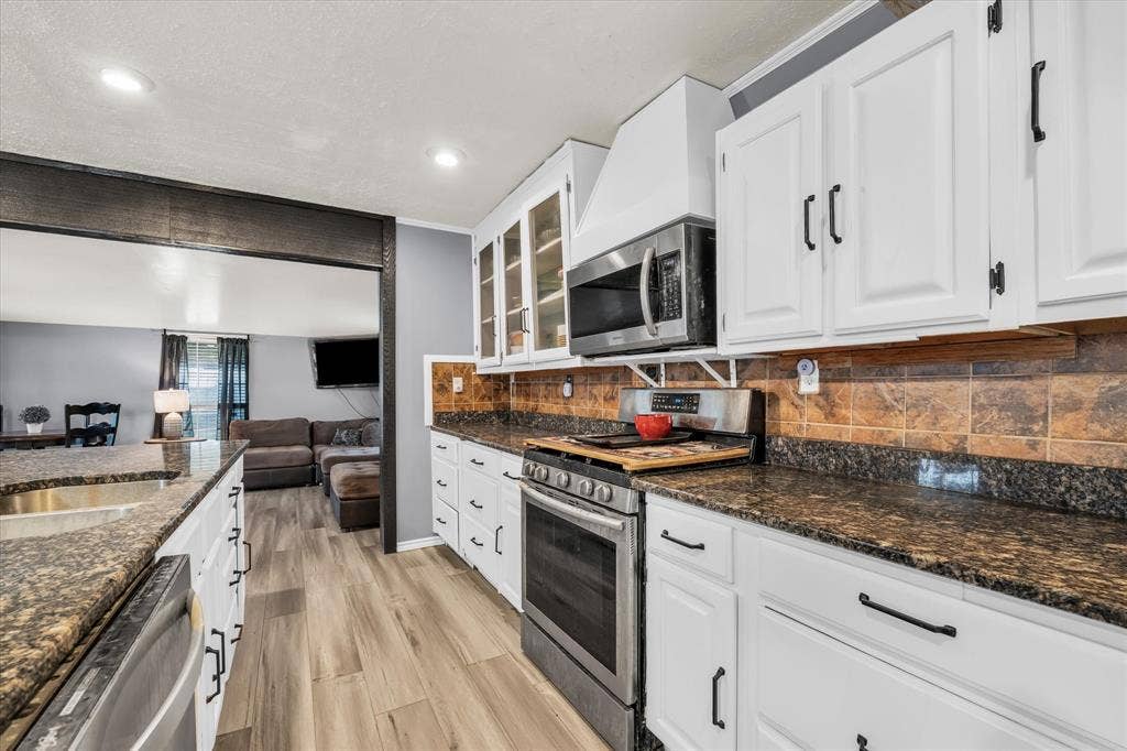 12912 Spring Valley Road, Moody, TX 76557 Kitchen featuring white cabinetry with dark hardware, stone-finish countertops, and a tile backsplash