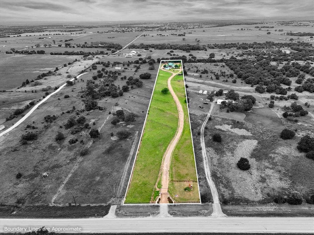 12912 Spring Valley Road, Moody, TX 76557 Expansive rural property featuring a long, winding gravel driveway and a green lawn