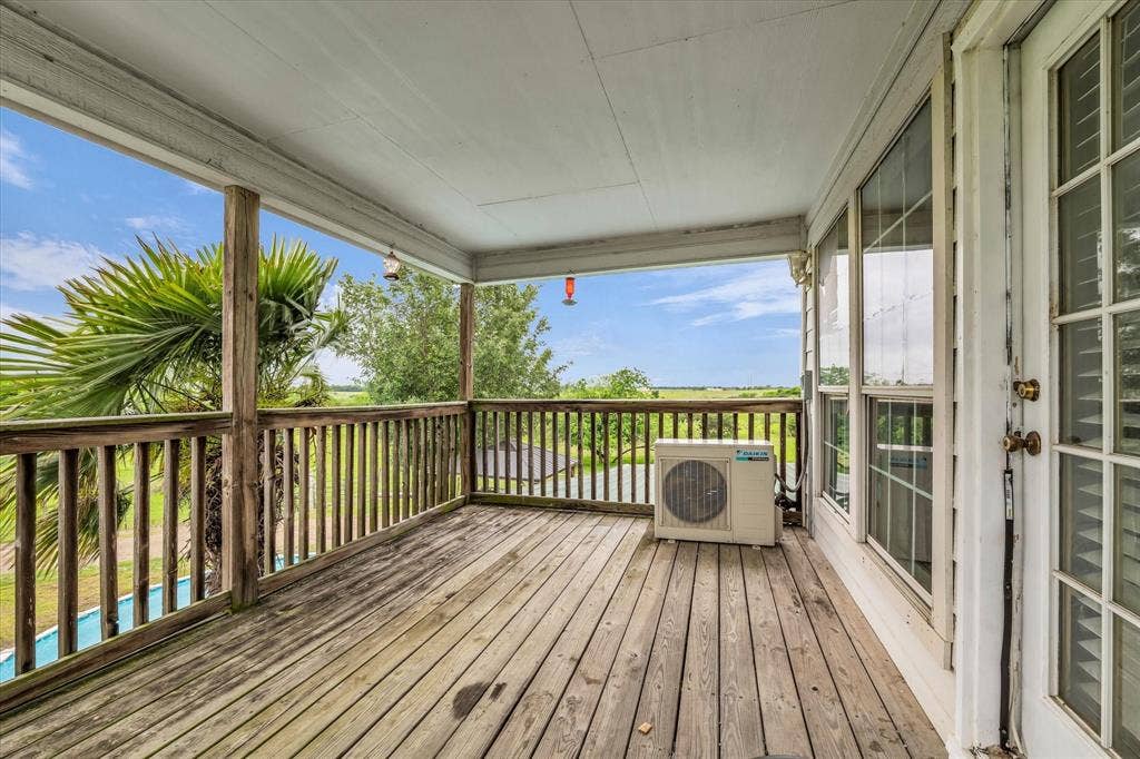 12912 Spring Valley Road, Moody, TX 76557 Covered wood-deck porch featuring a wooden railing, white ceiling, and exterior windows