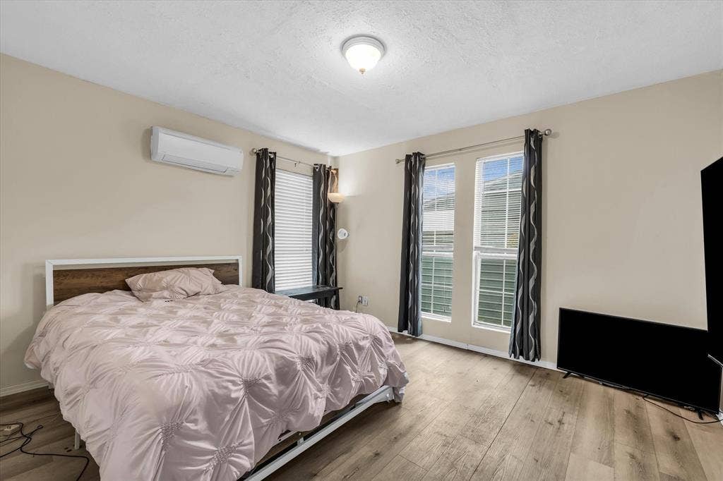 12912 Spring Valley Road, Moody, TX 76557 Spacious room featuring light-toned walls, wood-finish flooring, and two large windows with blinds