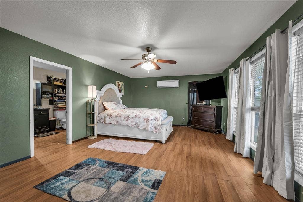 12912 Spring Valley Road, Moody, TX 76557 Spacious room featuring wood-finish flooring, a ceiling fan, and multiple windows